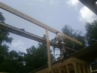 Carpenter setting a ridge beam over a new addition frame — Ice Dam Removal by Roofing Brothers in Pomfret