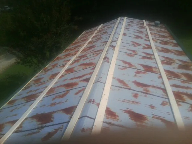 Rusted metal roof panels with new wood purlins before replacement — Storm Damage Roof Repair in Pomfret by Roofing Brothers