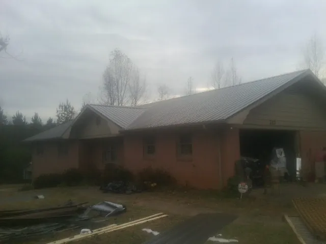 Gray metal roof on a stucco house with an attached garage in Pomfret