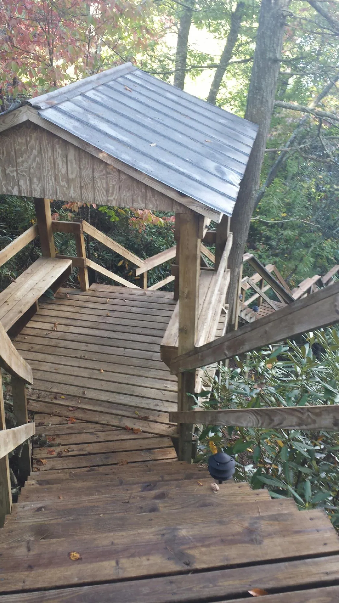 Metal roofed shelter over wooden steps on a wooded walkway — Skylight Repair & Installation work by our crew in Pomfret